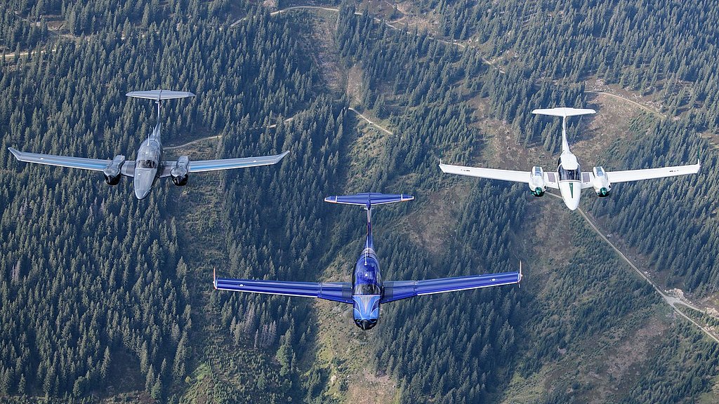 DA50 RG, DA62 and DA42-VI flying in formation over a forest.. 