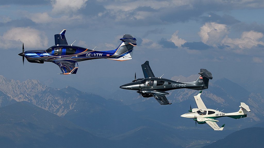 DA50 RG, DA62 and DA42-VI flying in formation over mountains. 