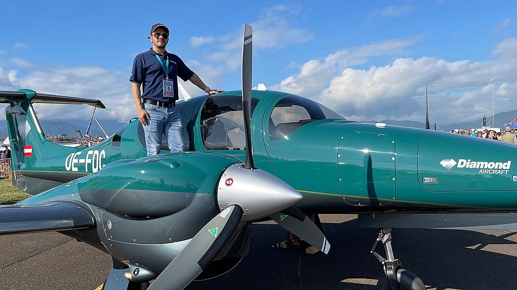 Diamond Aircraft team memember standing on a green DA62.