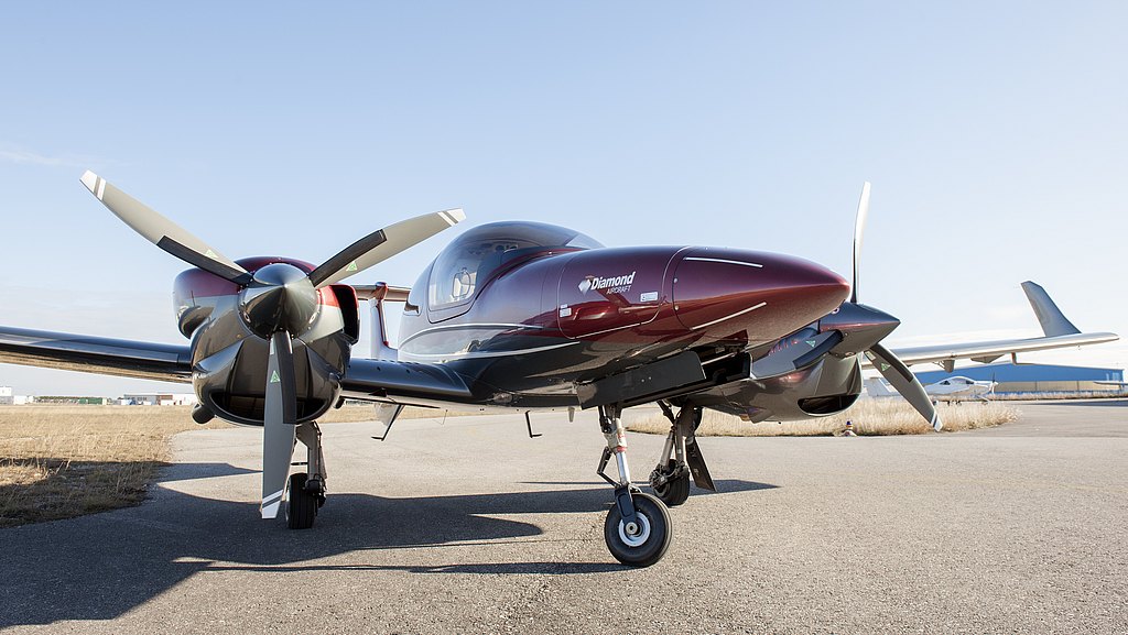 Red DA42-VI standing on the ramp. 