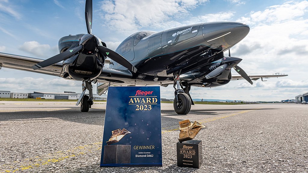 DA62 standing on the apron with fliegermagazin award and certificate in front of the aircraft. 