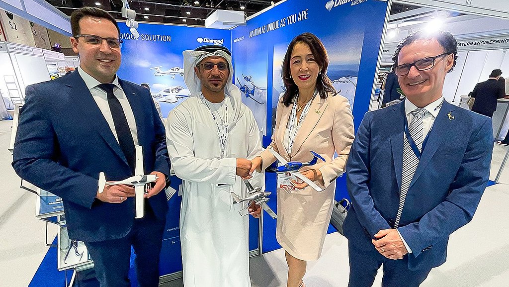 Diamond Aicraft team shaking hands with customer at Abu Dhabi Airshow booth.