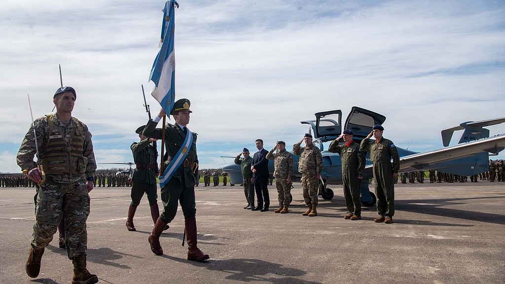 Army officials with the flag of Argentina marching by the DA62 MPP.