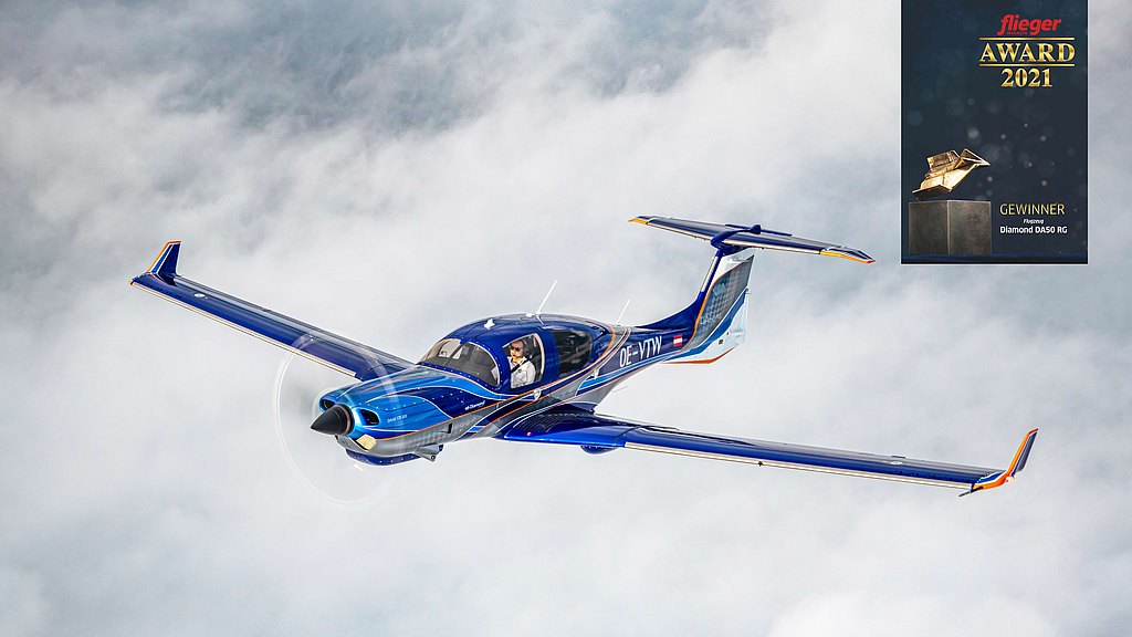 DA50 RG in blue and orange design soaring through clouds. 