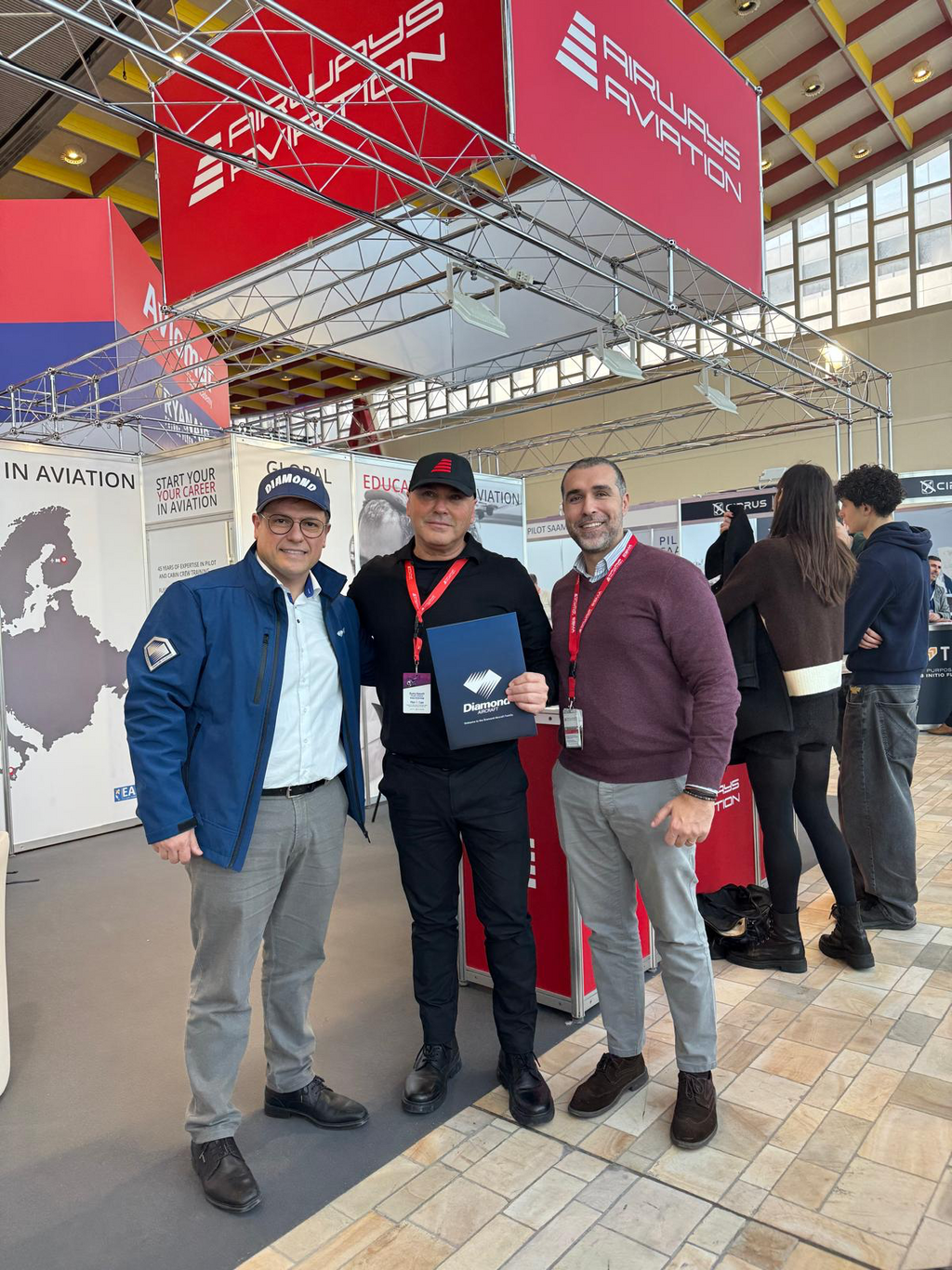 Three men stading at the Airways Aviation booth during the event.