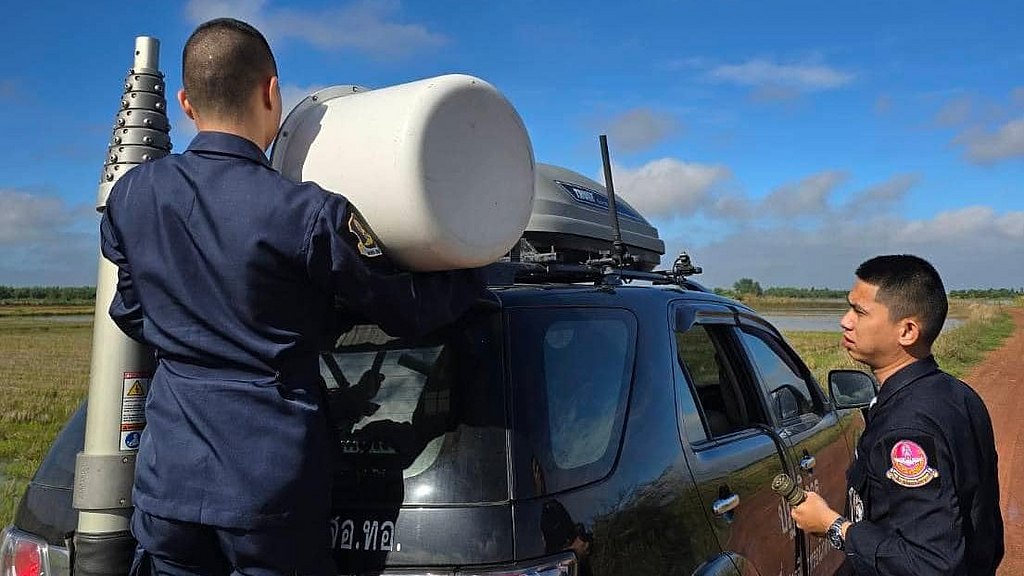 Two men preparing the ground command vehicle.