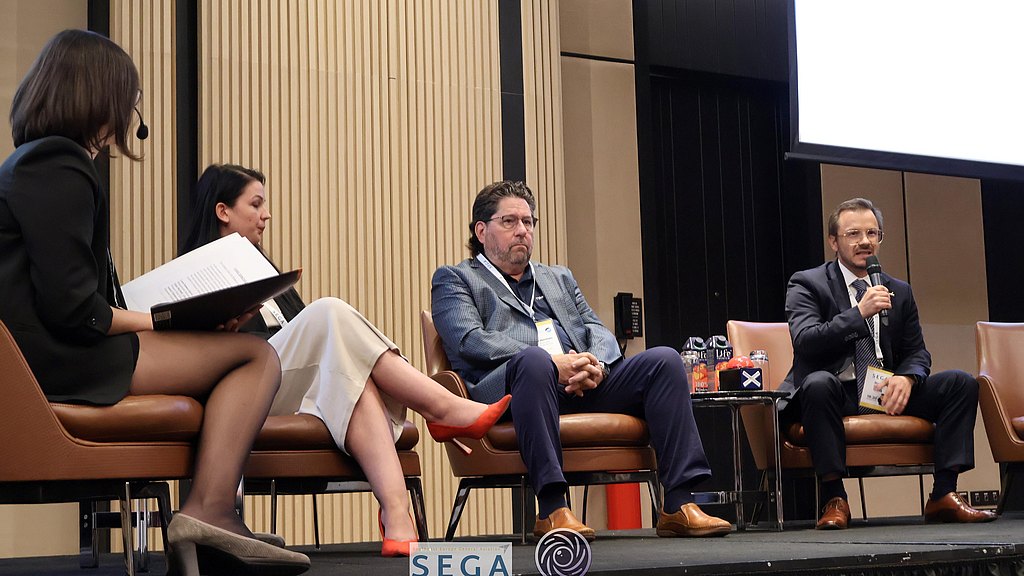 People sitting on a stage during a panel discussion.